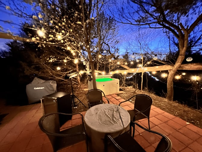 Private hot tub patio with string lights at night