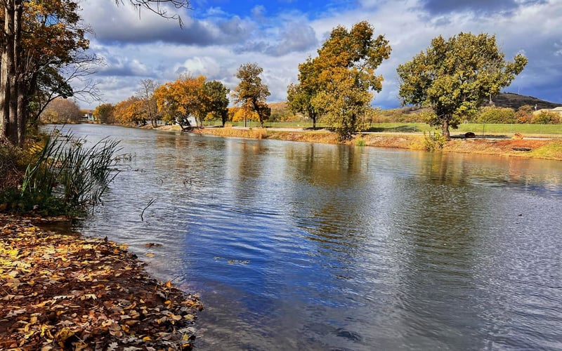 Medicine Park creek in autumn with golden trees and blue sky